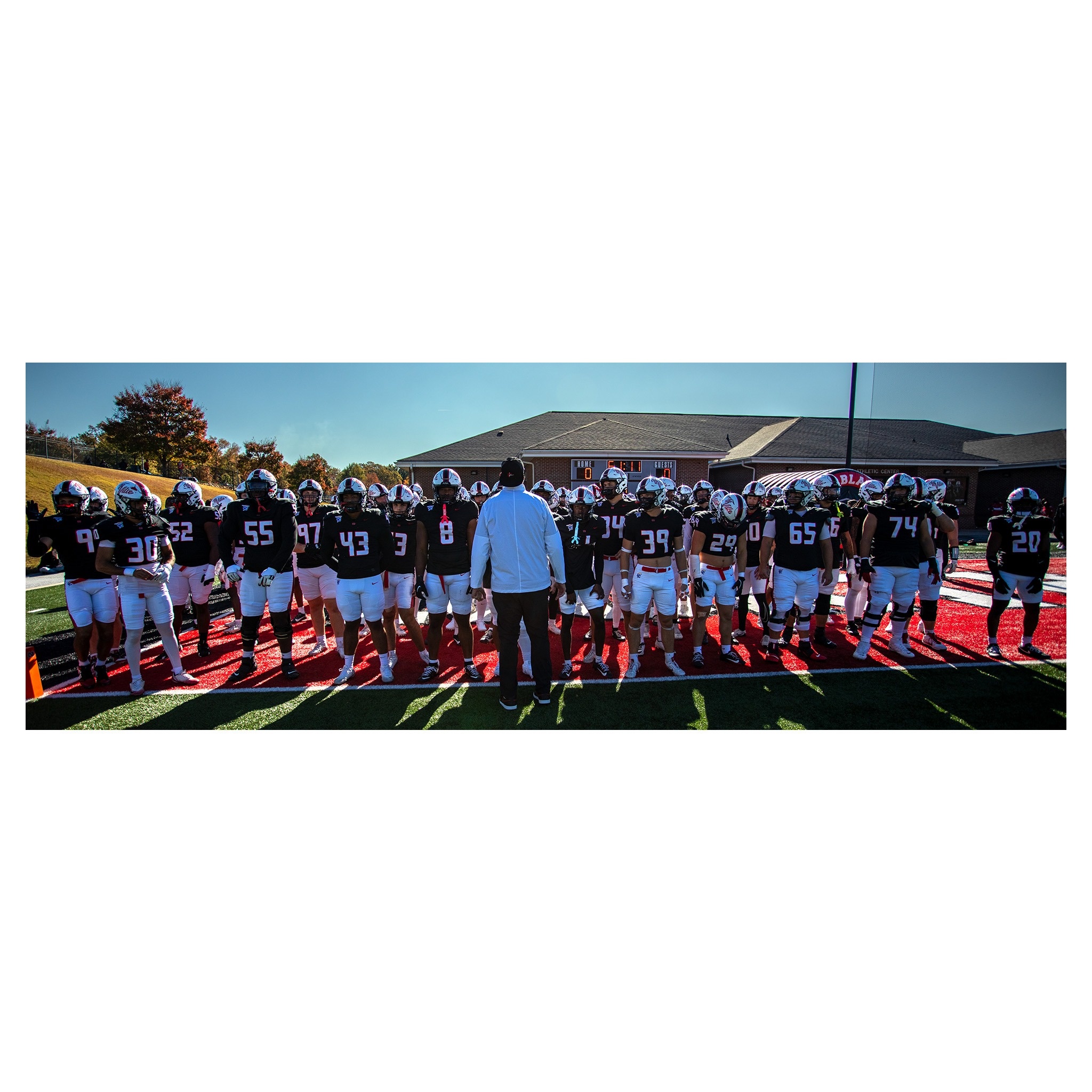 North Greenville football team in a huddle on the field